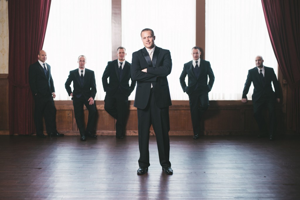 Groom with Groomsmen in the background  with Tom Studios Wedding Photography